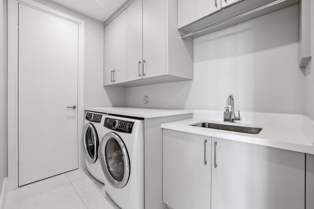 washroom with washer and dryer, light tile patterned flooring, cabinets, and sink