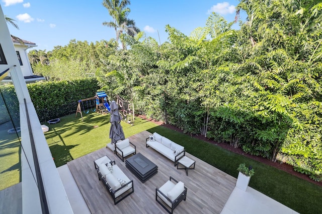 wooden deck featuring a playground, outdoor lounge area, and a lawn