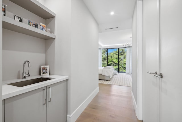 hallway with sink and light hardwood / wood-style flooring