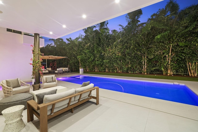 pool at dusk featuring outdoor lounge area and a patio