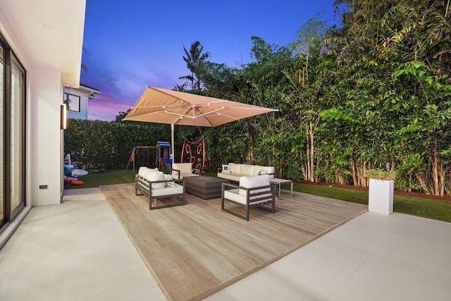 deck at dusk with an outdoor living space and a playground