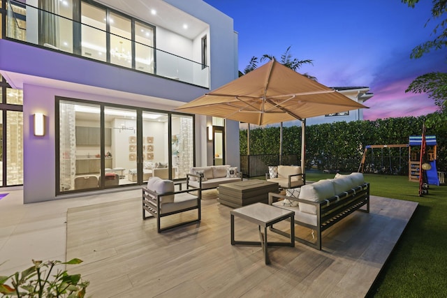 patio terrace at dusk with an outdoor living space and a playground