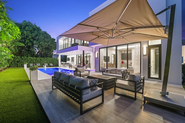 patio terrace at dusk with a fenced in pool and an outdoor living space