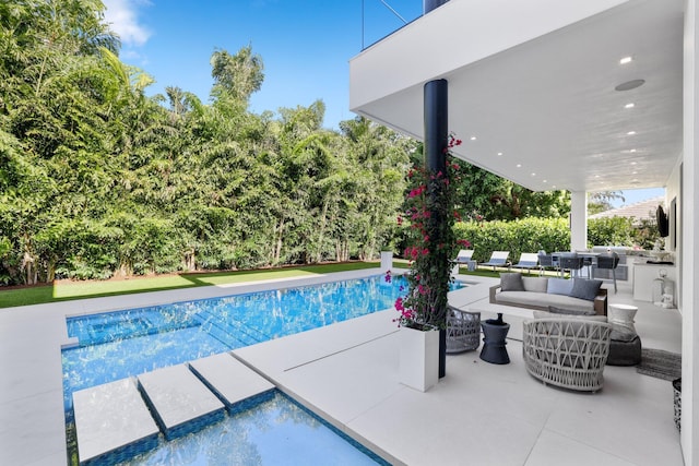 view of pool featuring an outdoor hangout area, a patio area, and exterior kitchen