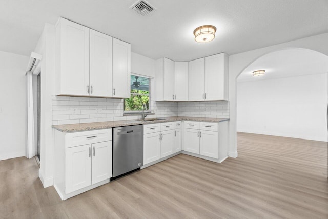 kitchen with sink, tasteful backsplash, stainless steel dishwasher, white cabinets, and light wood-type flooring