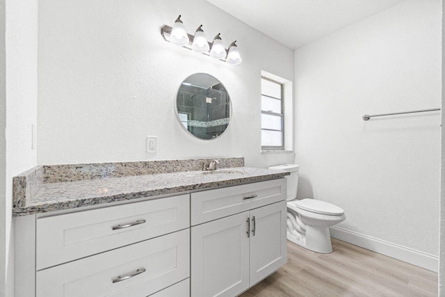 bathroom with hardwood / wood-style floors, vanity, and toilet