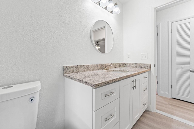 bathroom featuring hardwood / wood-style floors, ceiling fan, toilet, and vanity