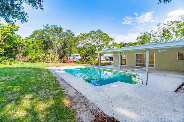 view of pool featuring a lawn and ceiling fan