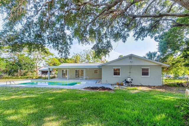 back of house with a lawn and a patio