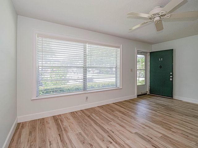 empty room with ceiling fan and light hardwood / wood-style floors