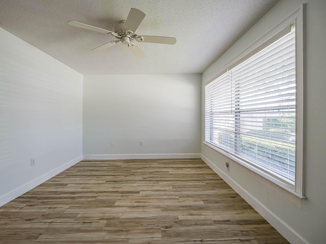 empty room with light hardwood / wood-style floors, ceiling fan, and a textured ceiling