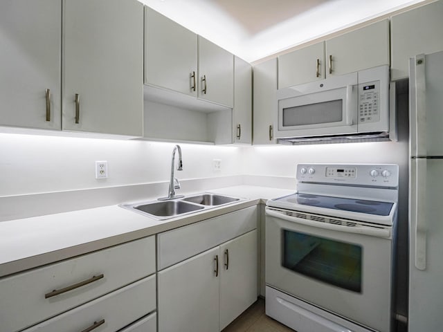 kitchen featuring white appliances, sink, and tile flooring