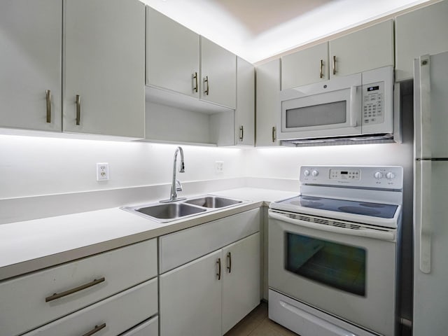 kitchen with sink, white appliances, and tile patterned floors