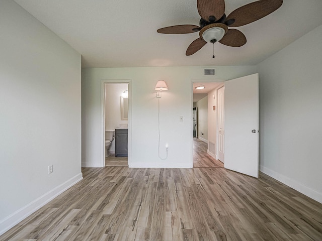 interior space featuring wood-type flooring, ensuite bath, and ceiling fan