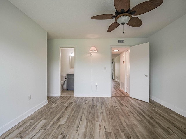 unfurnished bedroom with ceiling fan, light wood-type flooring, and ensuite bath