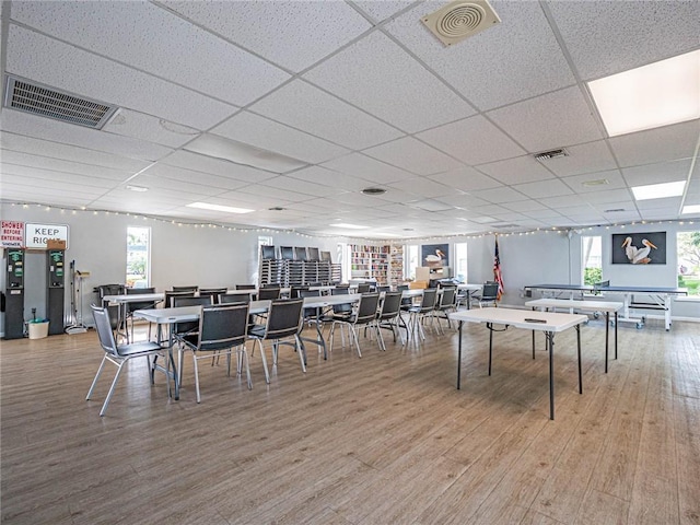 playroom with plenty of natural light, light hardwood / wood-style floors, and a drop ceiling