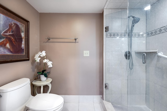 bathroom with toilet, tile patterned flooring, and a shower with door