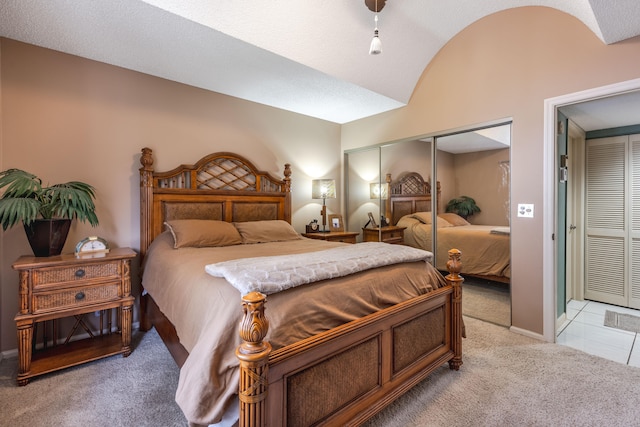 bedroom featuring carpet, a textured ceiling, lofted ceiling, and a closet