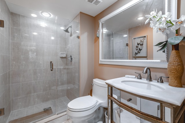 bathroom with a shower with door, vanity, and toilet