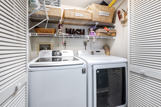 washroom with a textured ceiling and separate washer and dryer