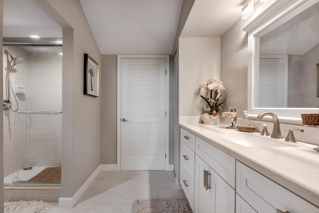 bathroom with an enclosed shower, a textured ceiling, and vanity