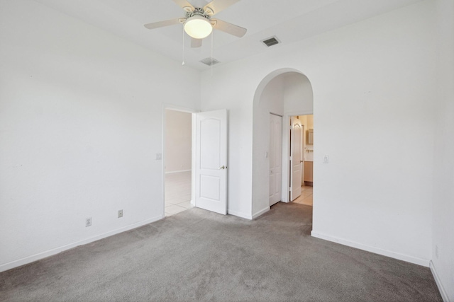 empty room with ceiling fan and light carpet