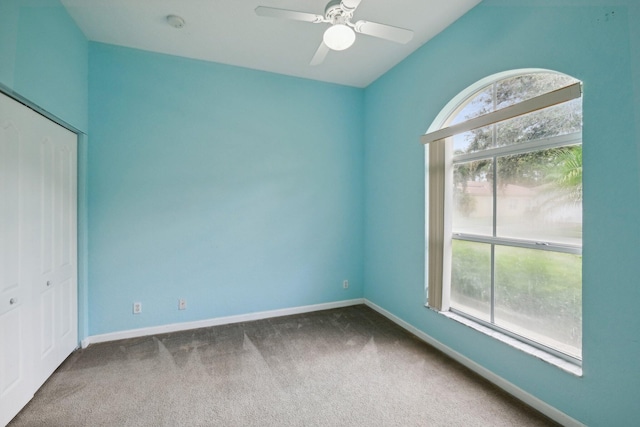 unfurnished bedroom with carpet floors, a closet, ceiling fan, and multiple windows