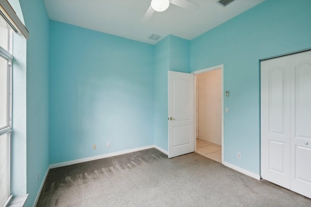 unfurnished bedroom featuring ceiling fan, a closet, and carpet