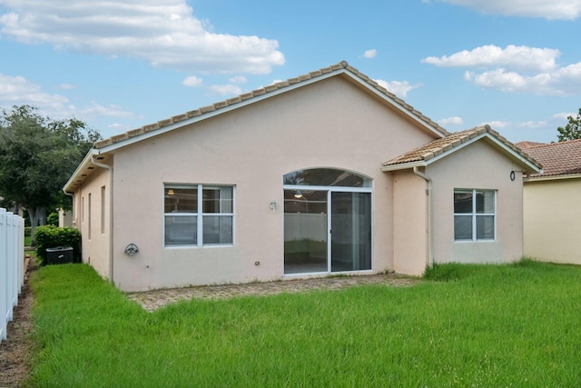 rear view of house featuring a yard