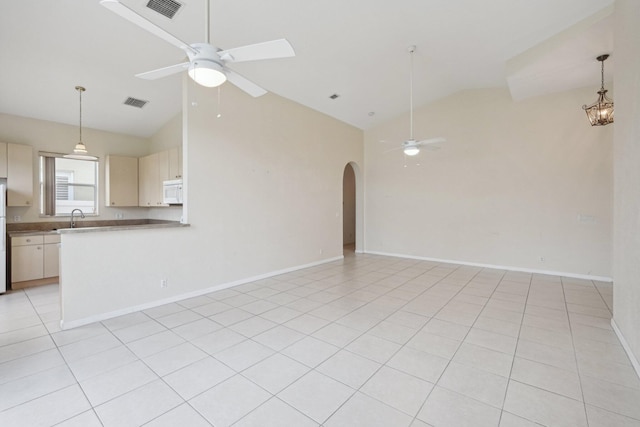 unfurnished living room with high vaulted ceiling, light tile patterned floors, sink, and ceiling fan