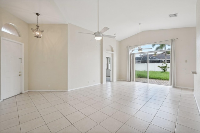 tiled spare room with ceiling fan with notable chandelier and high vaulted ceiling