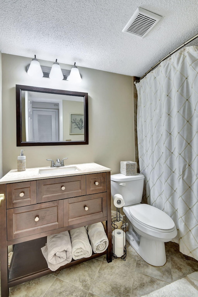 bathroom featuring vanity, toilet, a textured ceiling, and walk in shower