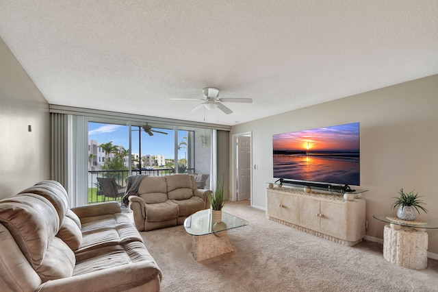 living room with a textured ceiling, light colored carpet, and a wall of windows