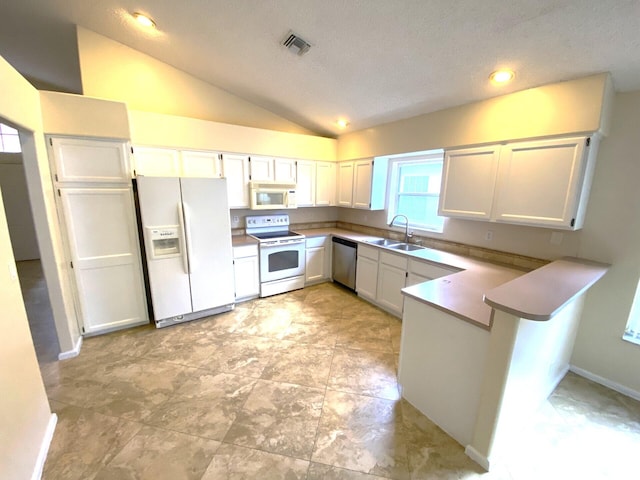 kitchen featuring white appliances, sink, vaulted ceiling, white cabinetry, and kitchen peninsula