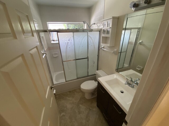 full bathroom featuring toilet, vanity, and combined bath / shower with glass door