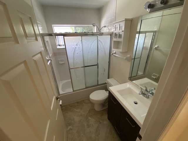 full bathroom featuring vanity, enclosed tub / shower combo, and toilet