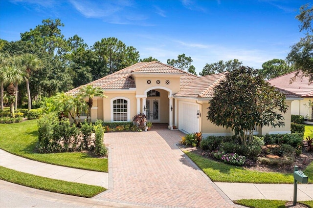 mediterranean / spanish-style house with a front yard and a garage