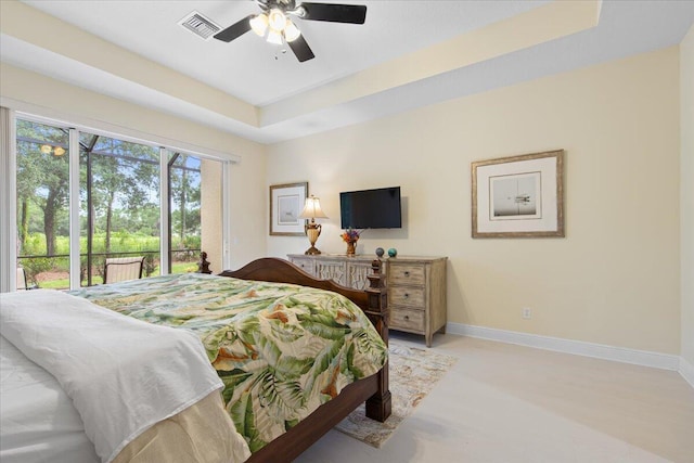 bedroom with a raised ceiling, access to exterior, and ceiling fan