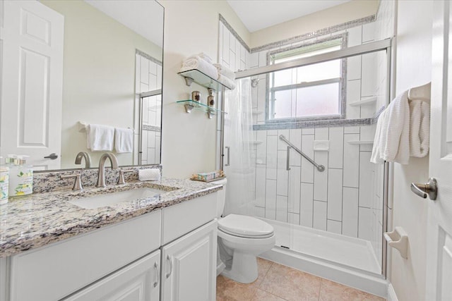 bathroom featuring vanity, toilet, tile patterned flooring, and a shower with door