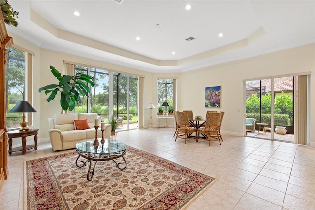 living room with crown molding, a raised ceiling, and light tile patterned floors