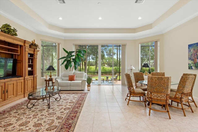 interior space with a raised ceiling, ornamental molding, and light tile patterned floors