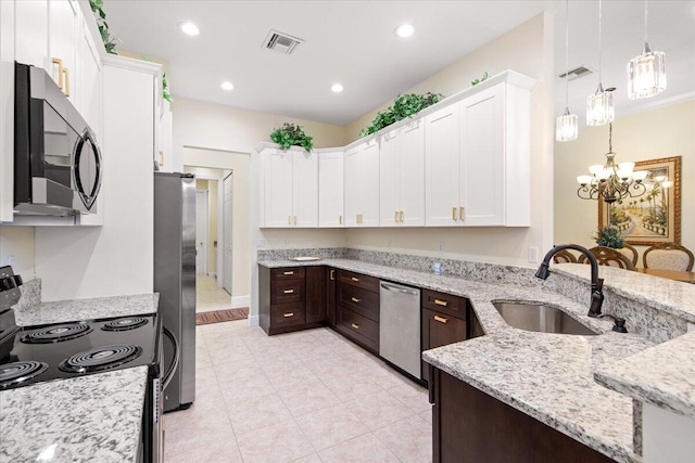 kitchen with pendant lighting, white cabinetry, sink, stainless steel appliances, and light stone countertops