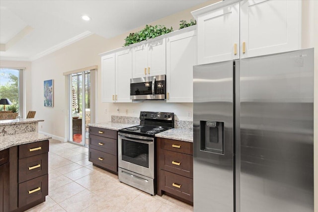 kitchen with appliances with stainless steel finishes, a wealth of natural light, and white cabinets