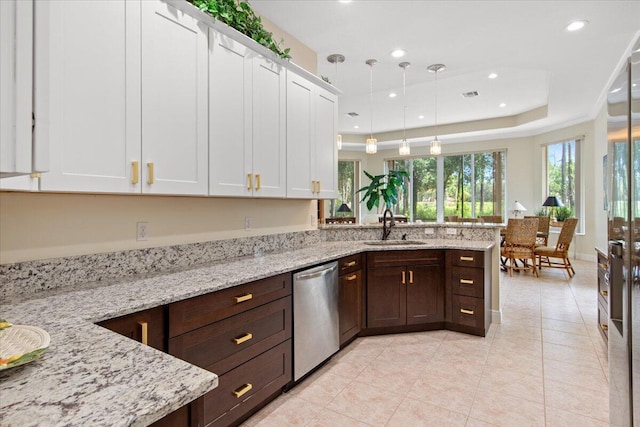 kitchen featuring pendant lighting, sink, light stone counters, white cabinets, and stainless steel dishwasher