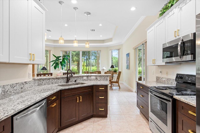 kitchen with pendant lighting, stainless steel appliances, and white cabinets