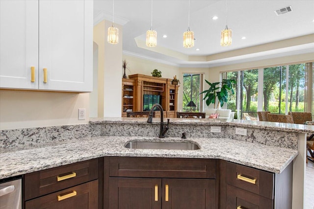 kitchen featuring sink, white cabinetry, light stone counters, decorative light fixtures, and dark brown cabinets