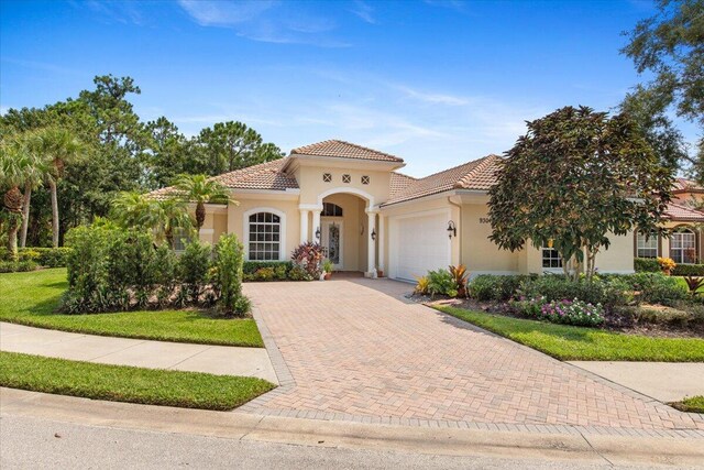 mediterranean / spanish-style house with a garage and a front yard