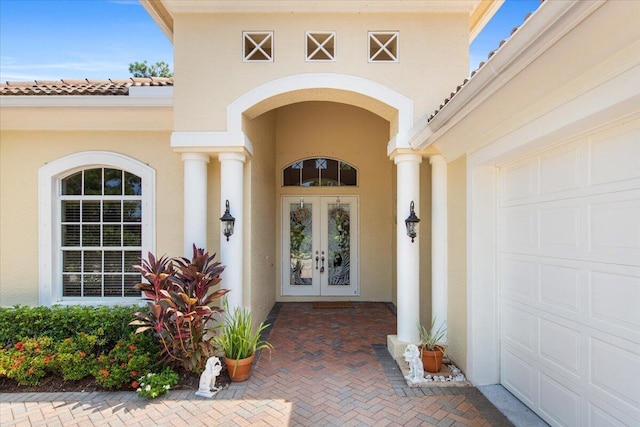 view of exterior entry featuring french doors and a garage