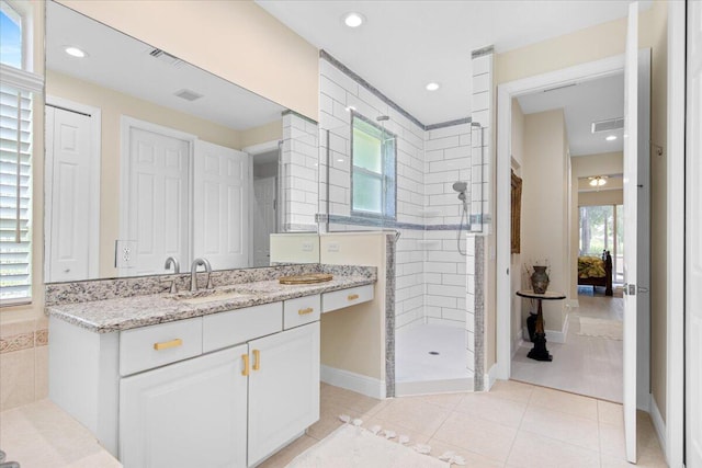 bathroom featuring vanity, tile patterned floors, and tiled shower