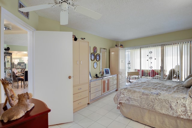 bedroom featuring ceiling fan, light tile patterned flooring, and a textured ceiling